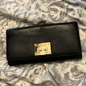Black Micheal Kors wallet, with metal logo clasp.